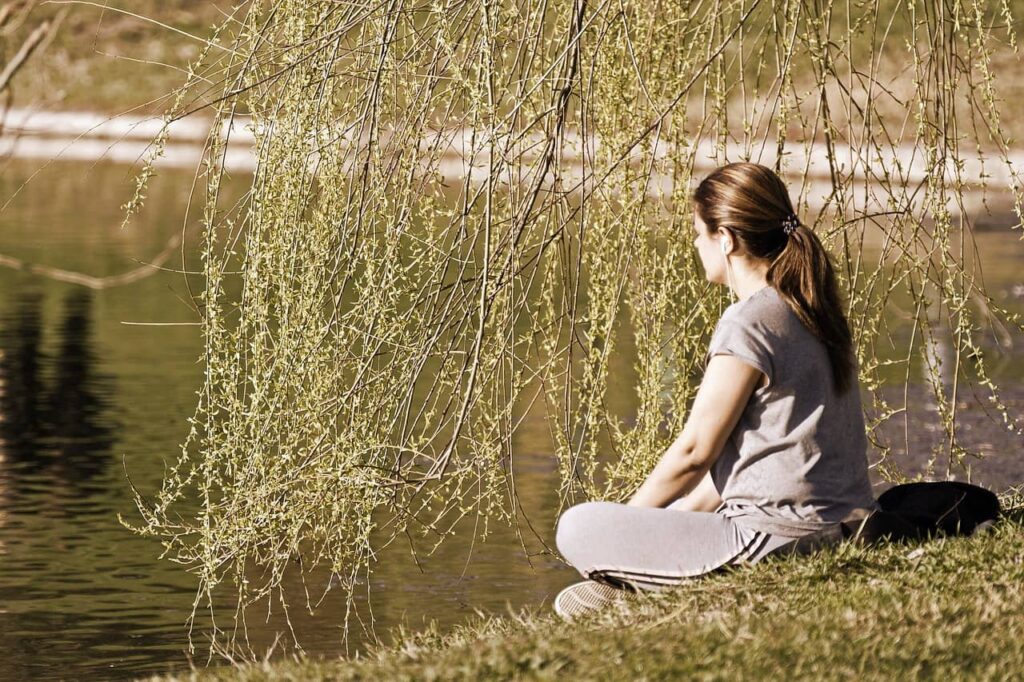 מדיטציית מיינדפולנס בטבע - אישה במדיטציה להפחתת חרדה ושיפור בריאות נפשית