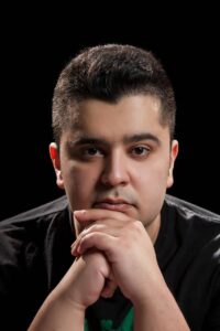 גבר צעיר עם מבט מהורהר וידיים מחוברות - ביטוי למחשבות שליליות ודיבור עצמי פנימי